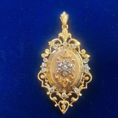 a close up of a gold broochle with diamonds on a blue background