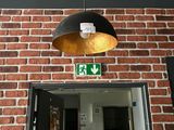 un mur de briques avec une lampe suspendue au plafond