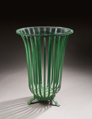 un vase en verre vert posé sur une table blanche