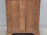 a wooden cabinet with a marble top on a cement floor