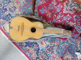 une guitare posée sur un tapis, par terre