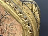 a close up of a gold frame with a painting on it