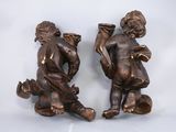 pair of antique bronze figurines of a boy and a girl sitting on the ground