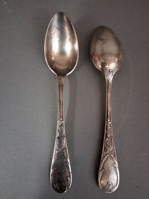 two spoons that are sitting side by side on a table