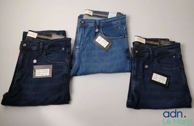 trois paires de jeans pour homme empilées les unes sur les autres