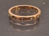 a gold ring with diamonds on it sitting on a table