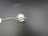 une bague en or sertie d'une perle blanche sur un fond noir