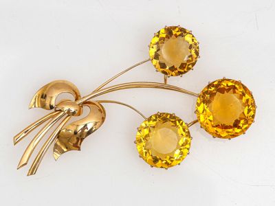 une image représentant une broche ornée de cristaux jaunes sur un fond blanc