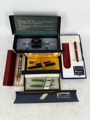 une boîte contenant un stylo, un stylo et d'autres objets
