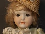 a doll that is wearing a hat and a dress