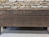 a wooden chest sitting on the floor in front of a stone wall