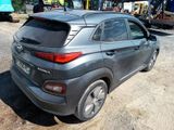 the rear end of a gray car parked in a parking lot