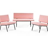 three pink chairs and a couch in a room with a white background