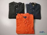 trois chemises pour homme de couleurs différentes posées sur une table