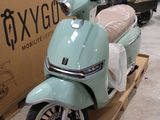 un scooter posé sur une palette devant une boîte