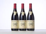 three bottles of red wine sitting on top of a table