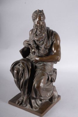 statue of a man sitting on a stool holding a book