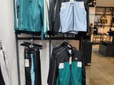 a lot of clothes that are on a rack in a store