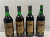 four bottles of wine are lined up on a table