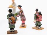 several figurines of people are standing on small wooden bases