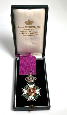 l'image d'une médaille dans un étui entouré d'un ruban