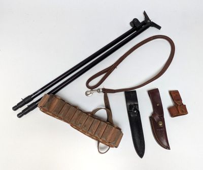 an image of a knife, sheath, and other items laid out on a white surface