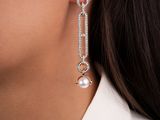 a woman wearing a white shirt and silver earrings