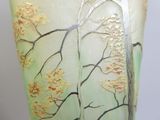 a glass vase with a painting of a tree on it