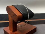 un présentoir en bois sur lequel est posé un sac à main noir