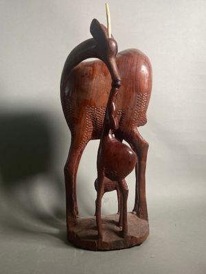 sculpture représentant une biche et son faon, posée sur un socle en bois