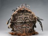 une image représentant un masque en bois orné de plumes