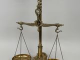 an antique brass scale with a bird on top of it