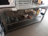 un micro-ondes posé sur une table en acier inoxydable