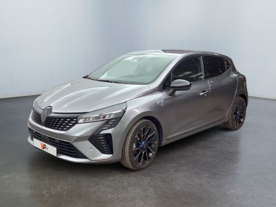 Une voiture argentée est garée dans une pièce au sol noir.