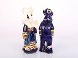 two figurines of a man and a woman standing next to each other