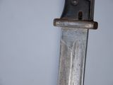 a close up of a knife hanging on a wall
