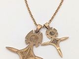 un gros plan d'un collier orné de deux oiseaux