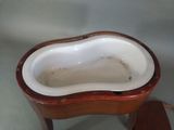 a small wooden table with a white porcelain bowl on top of it