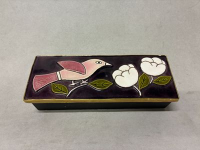 une petite boîte décorée d'un oiseau et de fleurs