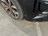 a man standing next to a car with a broken front bumper