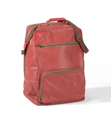 Le sac à dos est rouge et comporte deux fermetures éclair sur le devant.