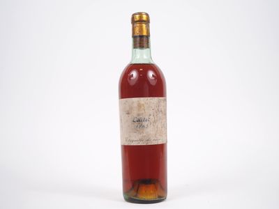 une vieille bouteille de vin posée sur une surface blanche