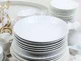 a lot of white plates and cups on the table