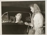 photographie en noir et blanc d'un homme et d'une femme dans une voiture