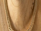 a close up of a mannequin wearing a gold chain necklace