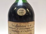 une vieille bouteille d'alcool posée sur une surface blanche