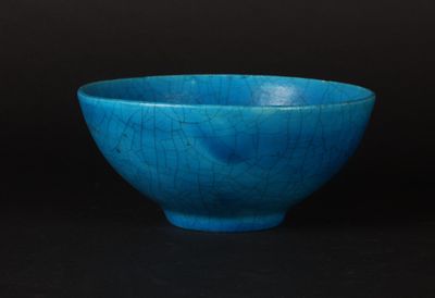 blue bowl with cracky surface on black background against black background