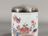 un gros plan d'un vase orné d'un oiseau et de fleurs