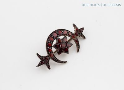 un gros plan d'une broche ornée de pierres rouges