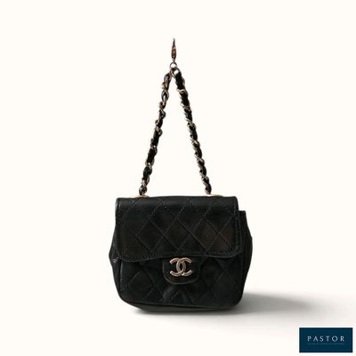 un sac Chanel noir auquel est suspendue une chaîne